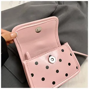 Détail du mini sac rose clair à pois avec fermoir magnétique argenté et texture fine