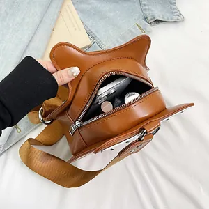 Vista dettagliata della borsa marrone a forma di violino con oggetti quotidiani