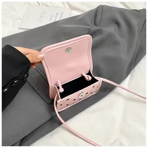 Détail du mini sac bandoulière rose à pois avec fermoir aimanté et doublure en tissu noir