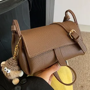 Premium σκούρα καφέ δερμάτινη τσάντα χιαστί με λευκές ραφές και διακοσμητικό τερατάκι