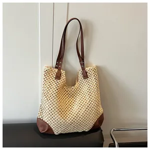 Close-up of hollow straw weave detail with leather trim and silver studs on tote bag