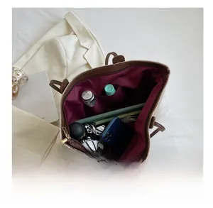 Detailed internal view of spacious canvas tote showing tablet, bottle and pockets