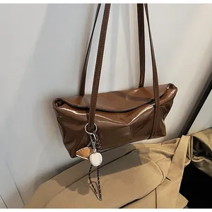 Close-up of shiny dark brown tote bag with glossy finish and sporty baseball charm