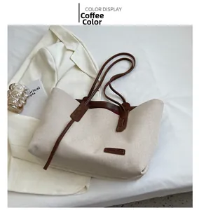 Detail of canvas tote bag showing brown leather logo patch and contrast trim accents