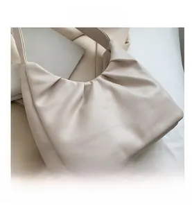 Detail of cream pleated cloud shoulder bag showing soft faux leather texture and elegant folds