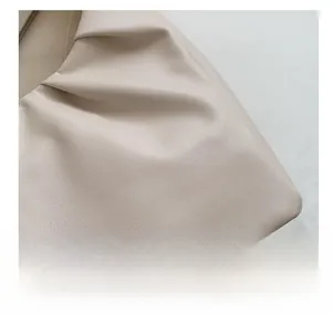 Detailed close-up of beige leather material featuring soft cloud-like pleats and textures