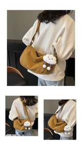 Detail of caramel corduroy crescent bag with a plush cloud pendant and adjustable strap