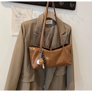 Detailed shot of brown wax leather shoulder bag with creative baseball glove pendant