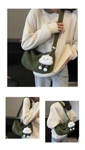 Detail of green corduroy crossbody dumpling bag with a cute white cloud plush pendant