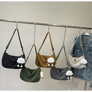 Corduroy crescent crossbody bags in five colors with cute cloud pendants hanging on a rack