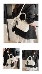 Detalle del bolso Boston blanco brillante con cintas de encaje y logo Clear K