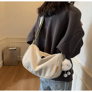 Minimalist beige corduroy crossbody bag shown with a plush cloud charm for a casual look