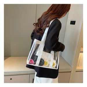 Detail of transparent PVC tote bag with white canvas straps and inner pouch on model