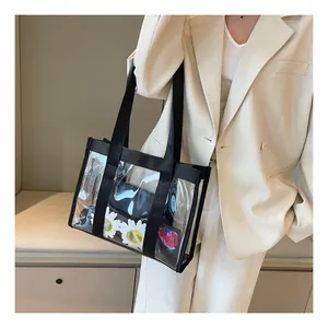 Detail of transparent PVC tote bag with black strap worn over a white suit jacket