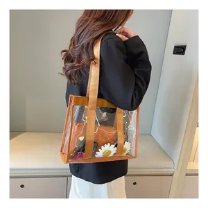 Detail of transparent PVC tote bag with brown straps and inner pouch on model