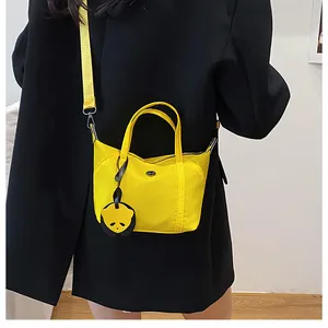 Detailed back view of a yellow dumpling bag on a model wearing a black blazer