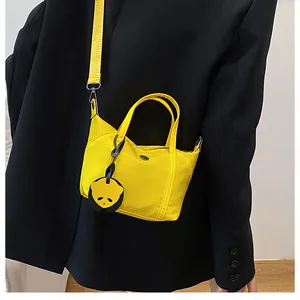 Detail of yellow nylon mini tote bag with panda charm and adjustable shoulder strap