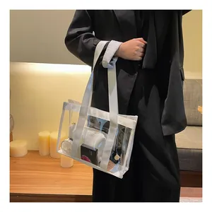 Detail of transparent PVC tote bag with white nylon handles showing interior storage space