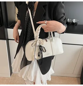 Detalle del bolso Boston blanco CLEAR K con encaje, perlas y cinta de seda suave