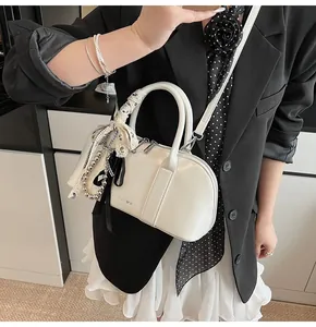 Detalle de bolso de cuero blanco con lazo de encaje y perlas para un estilo de oficina