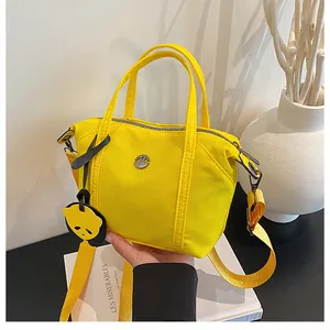 Detail of yellow nylon tote bag with panda charm and wide adjustable shoulder strap