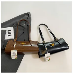 Detailansicht zweier Vintage Schultertaschen aus Leder in Karamell und Schwarz mit Metallelementen
