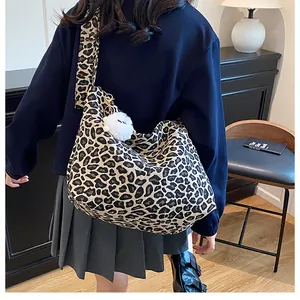 Détail d'un grand sac fourre-tout léopard en toile avec pompon décoratif blanc