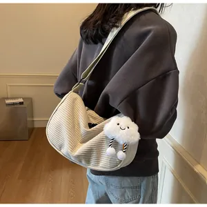 Detailed close-up of beige corduroy crossbody bag texture and plush cloud keychain charm
