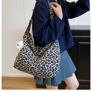 Détail du grand sac cabas en toile à motif léopard avec bandoulière et breloque mouton