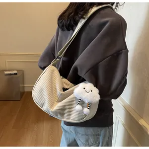 Close-up of beige corduroy crescent crossbody bag with cute plush cloud charm