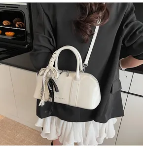 Primer plano de un bolso Boston blanco con lazos de encaje y abalorios de perlas en una cocina