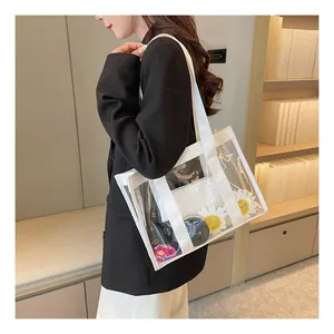 Close-up of a clear PVC tote bag with white reinforced handles and interior organizers