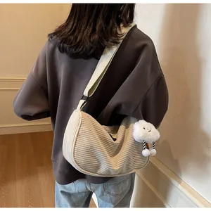 Detail of cream corduroy dumpling bag with a cute white cloud plush pendant and soft texture