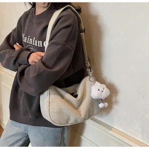 Detail of cream corduroy crossbody bag with wide strap and cute cloud charm