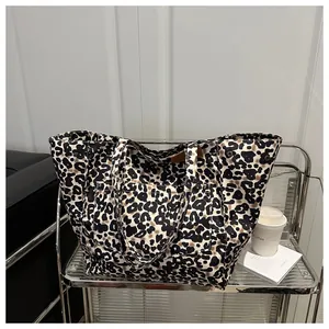 Detail of large leopard print canvas tote bag featuring a practical front pocket