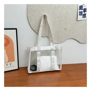 Detailed view of a transparent PVC tote bag with white strap and inner pouch