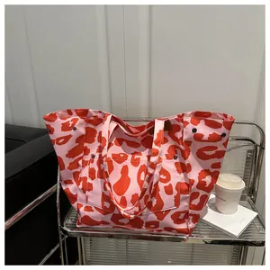 Detail view of pink and orange zebra print canvas tote bag with functional front pocket
