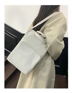 Detail of minimalist cream oxford tote bag with pleated texture on female model shoulder
