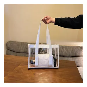 Detail of transparent PVC tote bag with white canvas straps and inner pouch for cosmetics