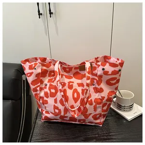 Detail of the pink canvas tote bag showing red leopard print and metal side snaps