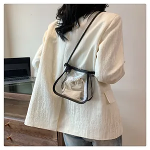 Close-up of transparent PVC crossbody bag with black trim and white inner pouch