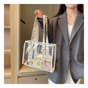 Detailed view of large transparent PVC tote bag featuring white handles with letter patterns