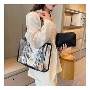 Detail of transparent PVC tote bag with daisy prints and woven shoulder strap