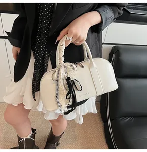 Detalle del bolso Boston blanco crema con cintas de encaje y logo Clear K en cuero vegano