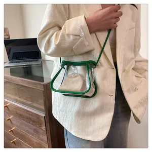 Detailed shot of transparent PVC crossbody bag with green trim and beige drawstring pouch