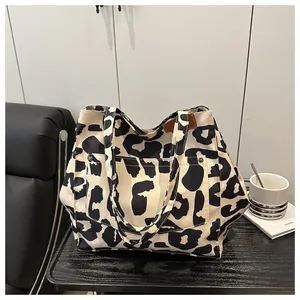 Close-up of leopard print canvas tote bag with front pocket and rivet details