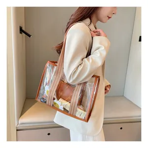 Detail showing transparent PVC tote with brown leather trim and striped woven strap
