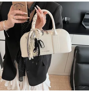 Primer plano de bolso de charol blanco con logotipo Clear Heart y colgantes decorativos