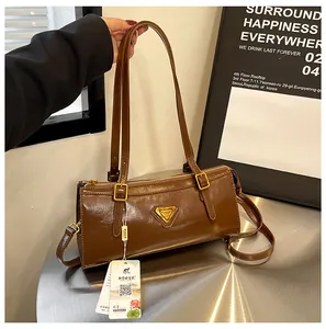 Detailansicht der dunkelbraunen Boston-Tasche mit glänzendem Leder und Goldbeschlägen