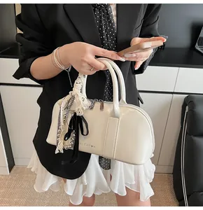 Detalle de bolso Boston de cuero PU blanco roto con lazo de encaje y colgante de cuentas